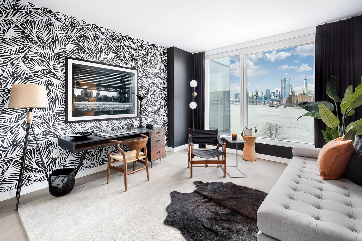 Modern Seating Area with Couch, Work Table, Funky Black and White Patterned Accent Wall, Wood Floors with Area Rug and Large Window with Waterfront and City Views