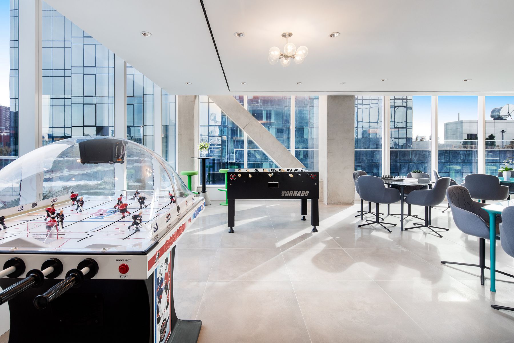 420 Kent - Game lounge with hockey and foosball game tables, chess, tables and seating throughout, bright and spacious with large windows